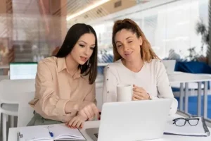 IT más equitativo: 4 estrategias de retención de talentos mujeres 6 Dos mujeres trabajando con una laptop en una oficina